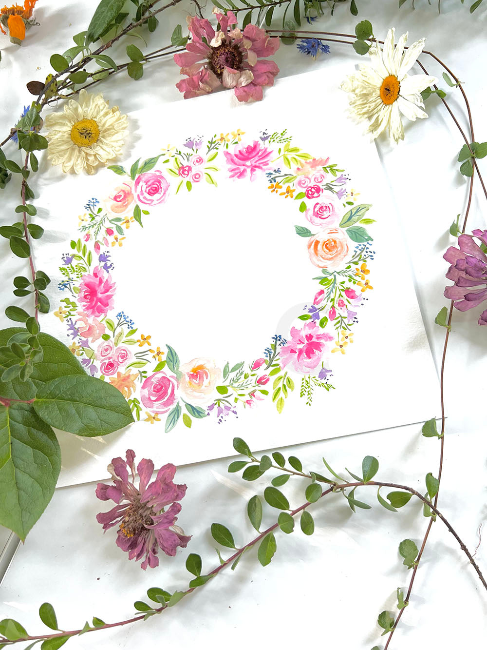 An original wreath flower painting featuring pink, purple blue and orange flowers &nbsp;painted in a circle.